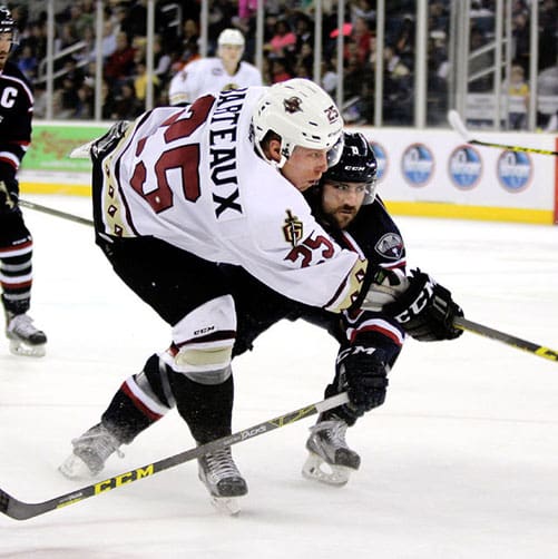 Two ice hockey players competing intensely on the ice rink.